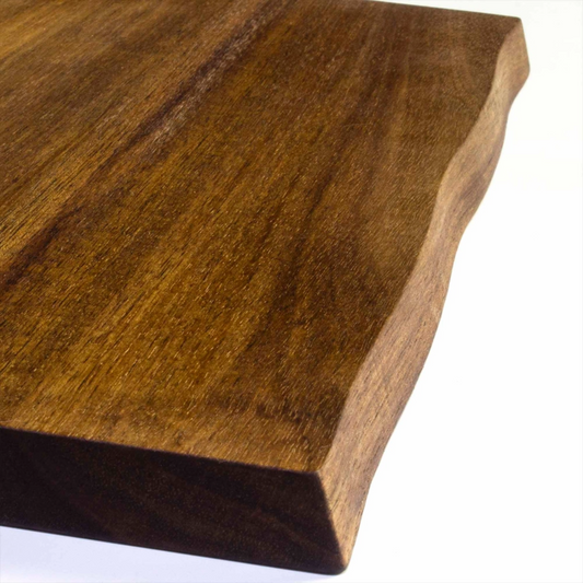 Close-up of acacia wood charcuterie board showing natural live edge and durable cutting surface.