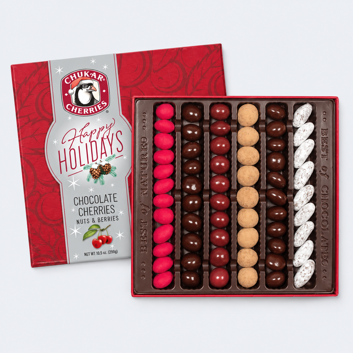 Chukar Cherries chocolate cherries and nuts & berries gift box, shown open with rows of chocolate-covered cherries, whole nuts, and white-speckled berries alongside the red holiday-themed packaging.