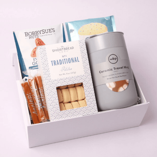 Elegant employee onboarding gift box filled with gourmet snacks, a ceramic travel mug, and sweet treats—perfect for corporate gifting and new hire welcomes.