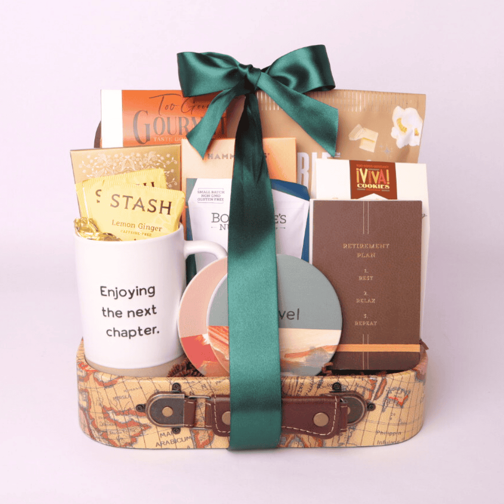 Retirement gift basket with travel themed goodies. Basket includes travel snacks, retirement mug, stone coasters, and notebook all assembled in a decorative mini suitcase.