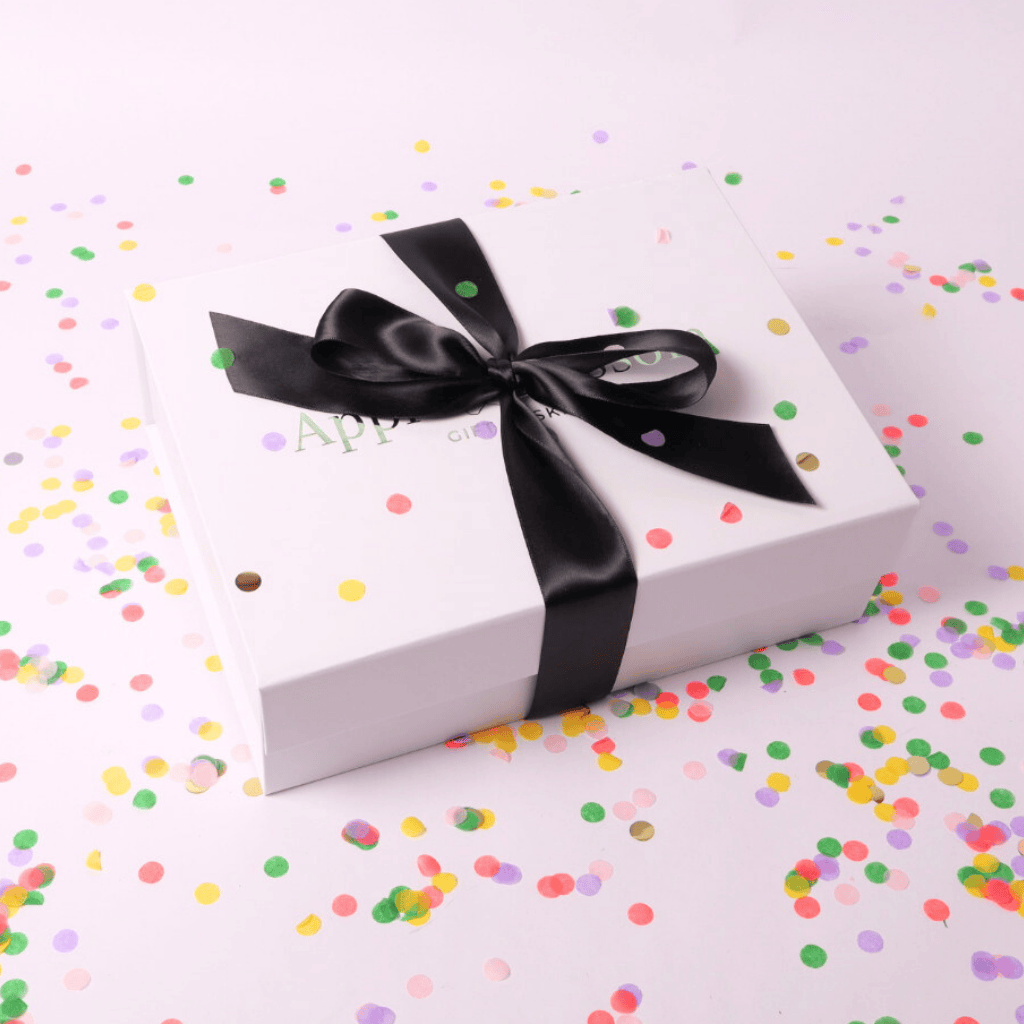 A sleek white gift box tied with a luxurious black satin bow, exuding elegance and perfect for any celebration.