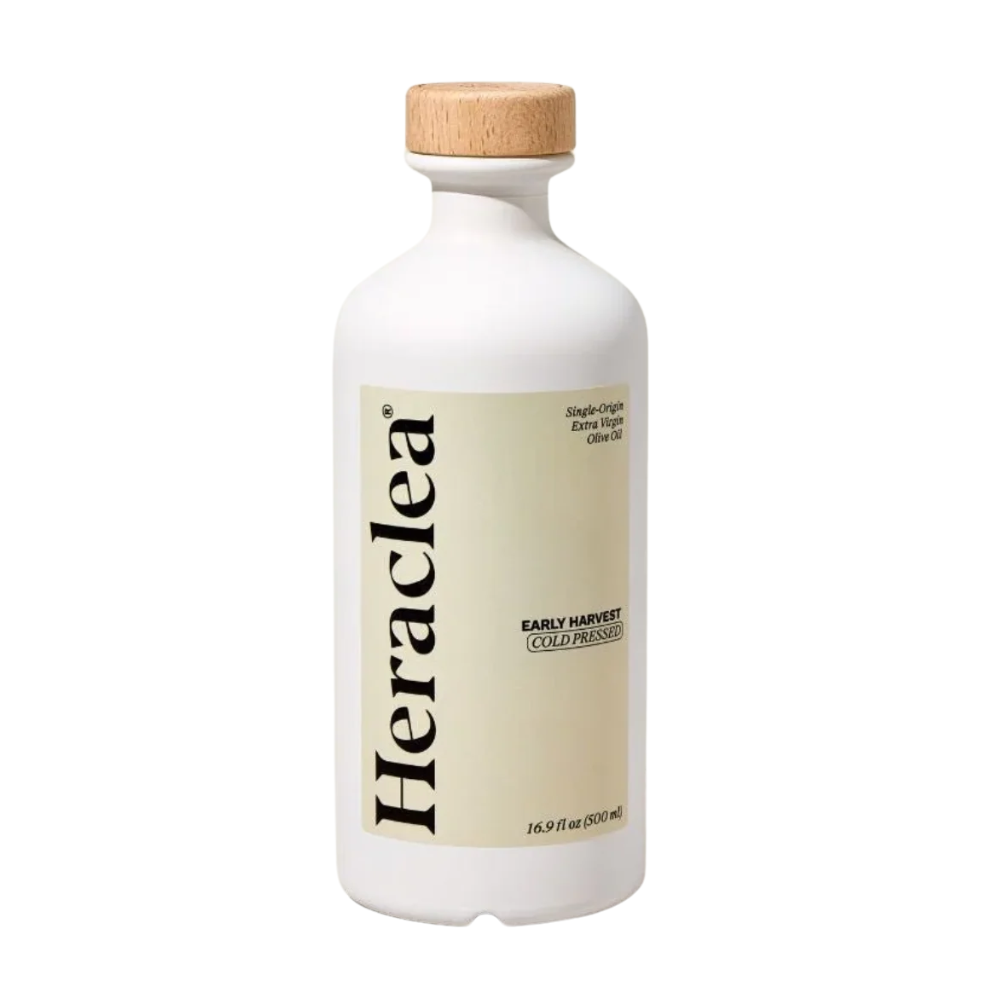 A white bottle of Heraclea Extra Virgin Cold Pressed Olive Oil with a light wood cap and a beige label, shown on a plain white background.