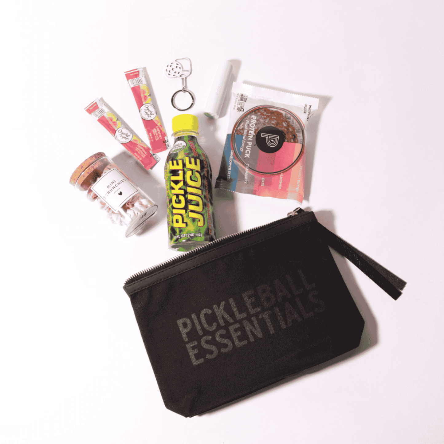 This unique pickleball gift is perfect for her, featuring a beautifully designed zipper pouch with high-quality, made in Washington products, including pickle juice and energy-boosting snacks for her next game!