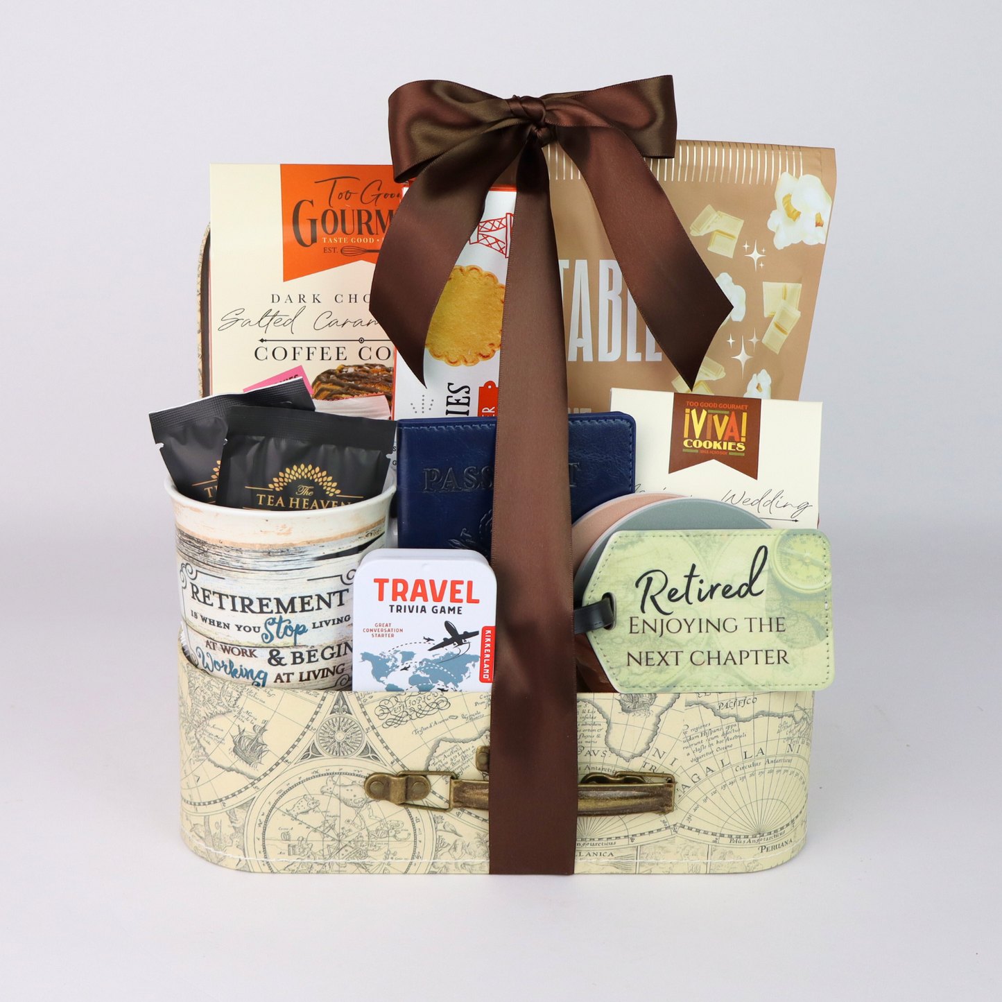 Retirement gift basket with travel themed goodies. Basket includes travel snacks, retirement mug, stone coasters, and notebook all assembled in a decorative mini suitcase.