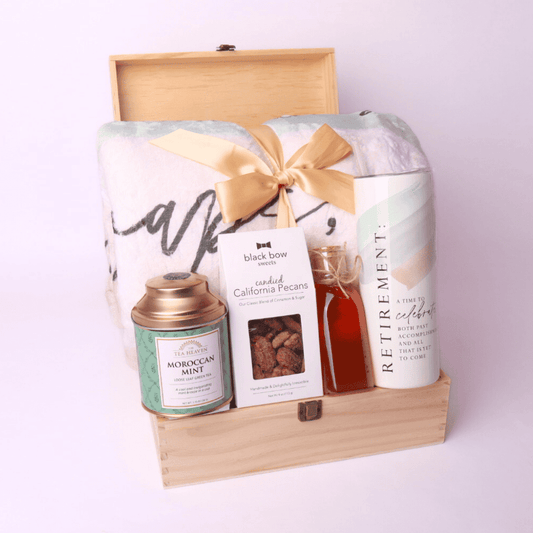 Full Gift Box with Contents Displayed Upright
Cozy retirement gift box with throw blanket, Moroccan mint tea from Seattle based Tea Heaven, candied pecans, Walla Walla honey jar, 20oz tumbler, all inside a keepsake wooden box with ribbon.