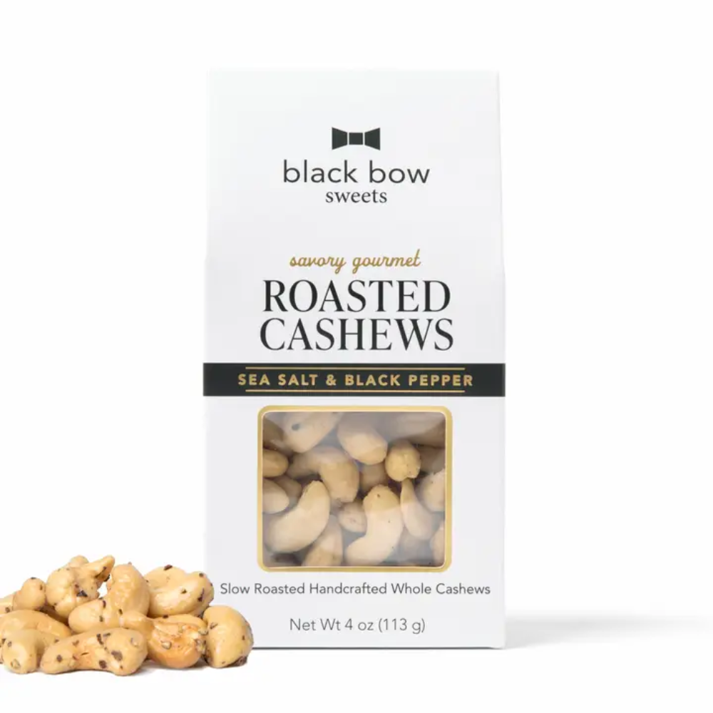 A package of Black Bow Sweets Savory Gourmet Roasted Cashews on a white background, with a few loose roasted cashews placed in front of the box.