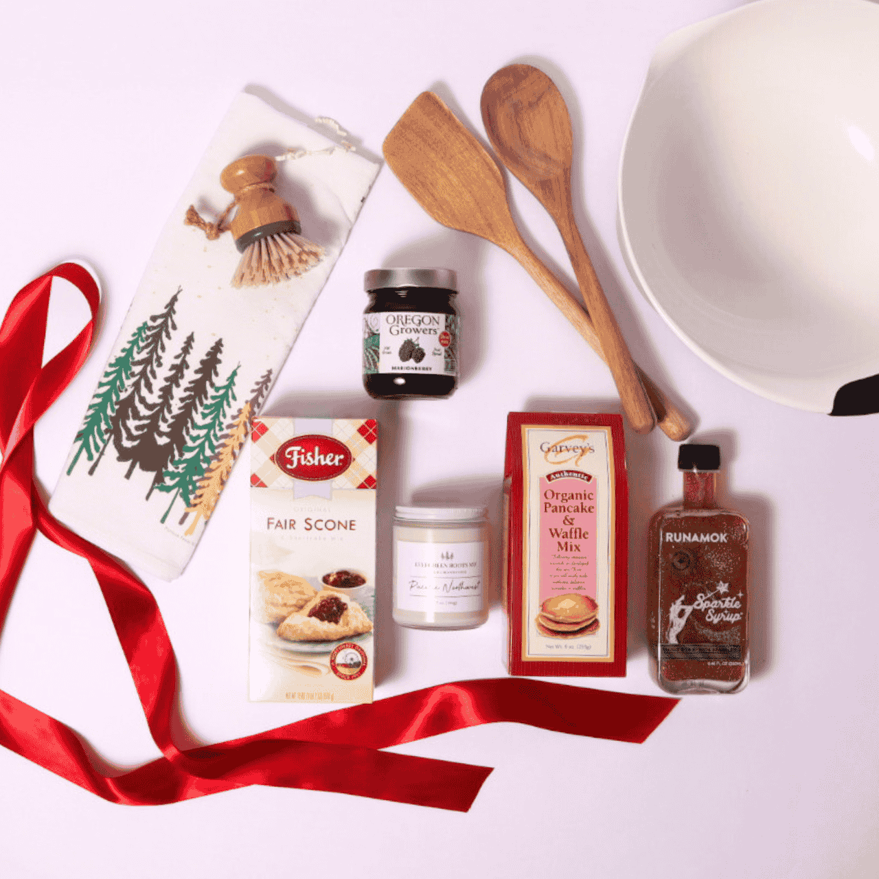 Gourmet baking gift set with scone mix, jam, pancake mix, wooden utensils, and a candle, beautifully arranged for a cozy Northwest-inspired breakfast gift