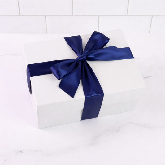 White gift box with a blue ribbon on a white tiled background