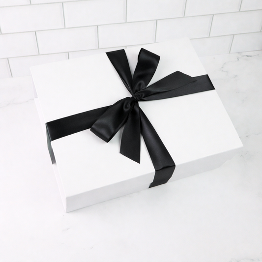 White gift box with a black ribbon on a white background