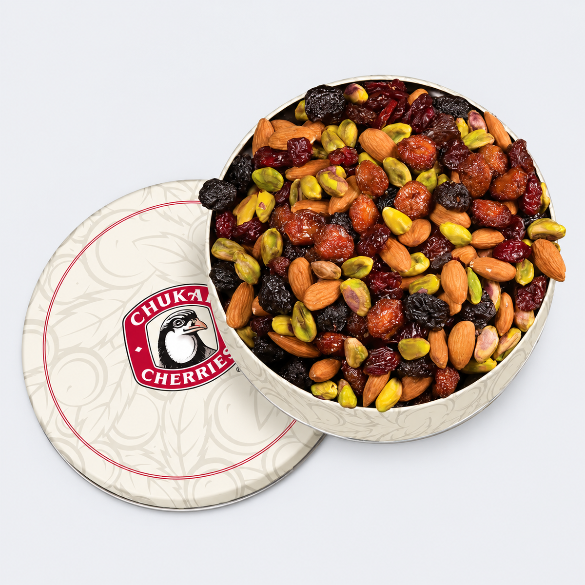 An open round tin of Chuka Cherries mixed nuts and dried fruit, with the branded lid placed beside it on a light gray background.