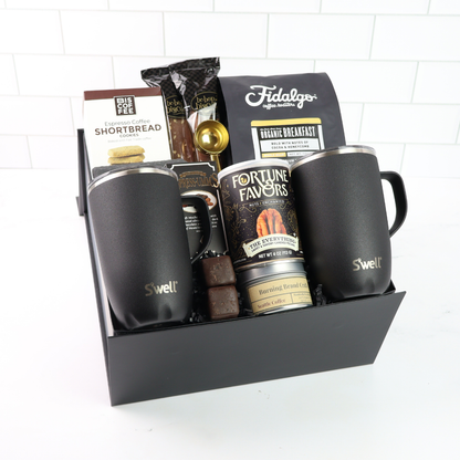 The Regal Seattle Coffee gift box in black signature packaging, filled with premium coffee essentials including double-walled ceramic mugs, Fidalgo organic coffee, and gourmet treats.