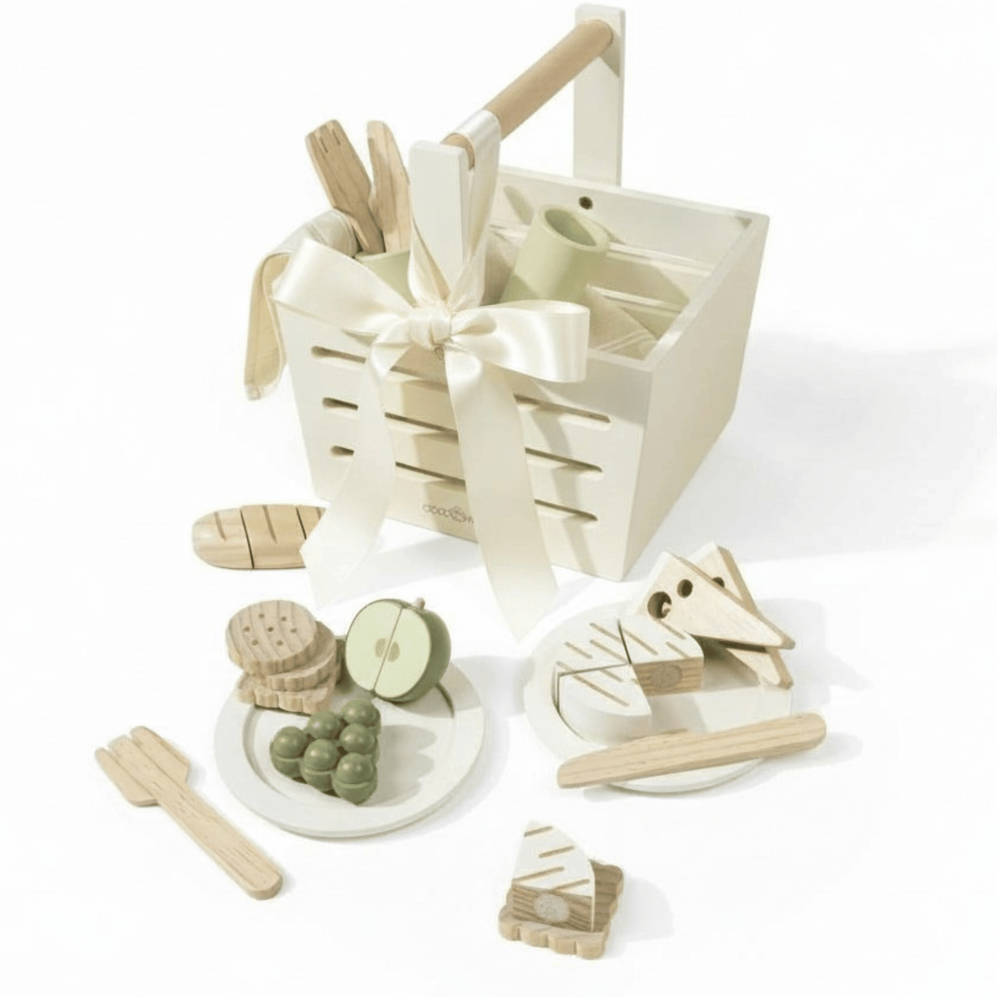 Wooden picnic basket with pretend fruit, crackers, bread, and utensils arranged in neutral tones.