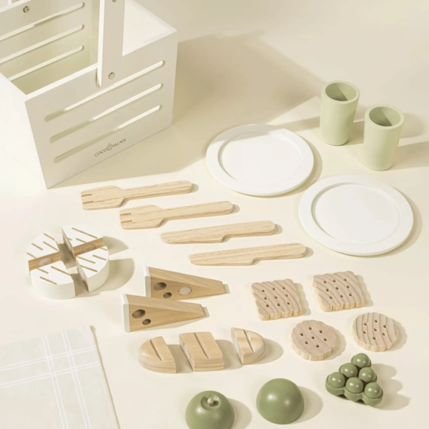 Montessori wooden picnic playset displayed with plates, cups, utensils, bread, cheese, fruit, and crackers.