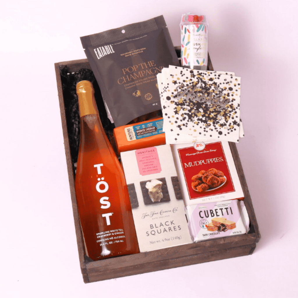 cue the confetti gift basket with non alcoholic drinks or champagne, cookies, cheese, crackers, popcorn and party popper.  Made in WA by Apple Blossom Gift Baskets