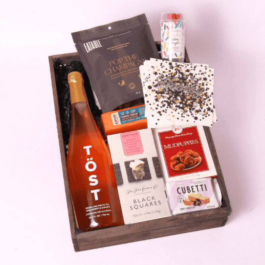 cue the confetti gift basket with non alcoholic drinks or champagne, cookies, cheese, crackers, popcorn and party popper.  Made in WA by Apple Blossom Gift Baskets