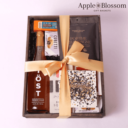 cue the confetti celebration gift basket comes in a wooden tray with cheese, crackers, white tea, wafer cookies, nuts, party popper, napkins and champagne infused white chocolate popcorn.  Made by Apple Blossom Gift Baskets