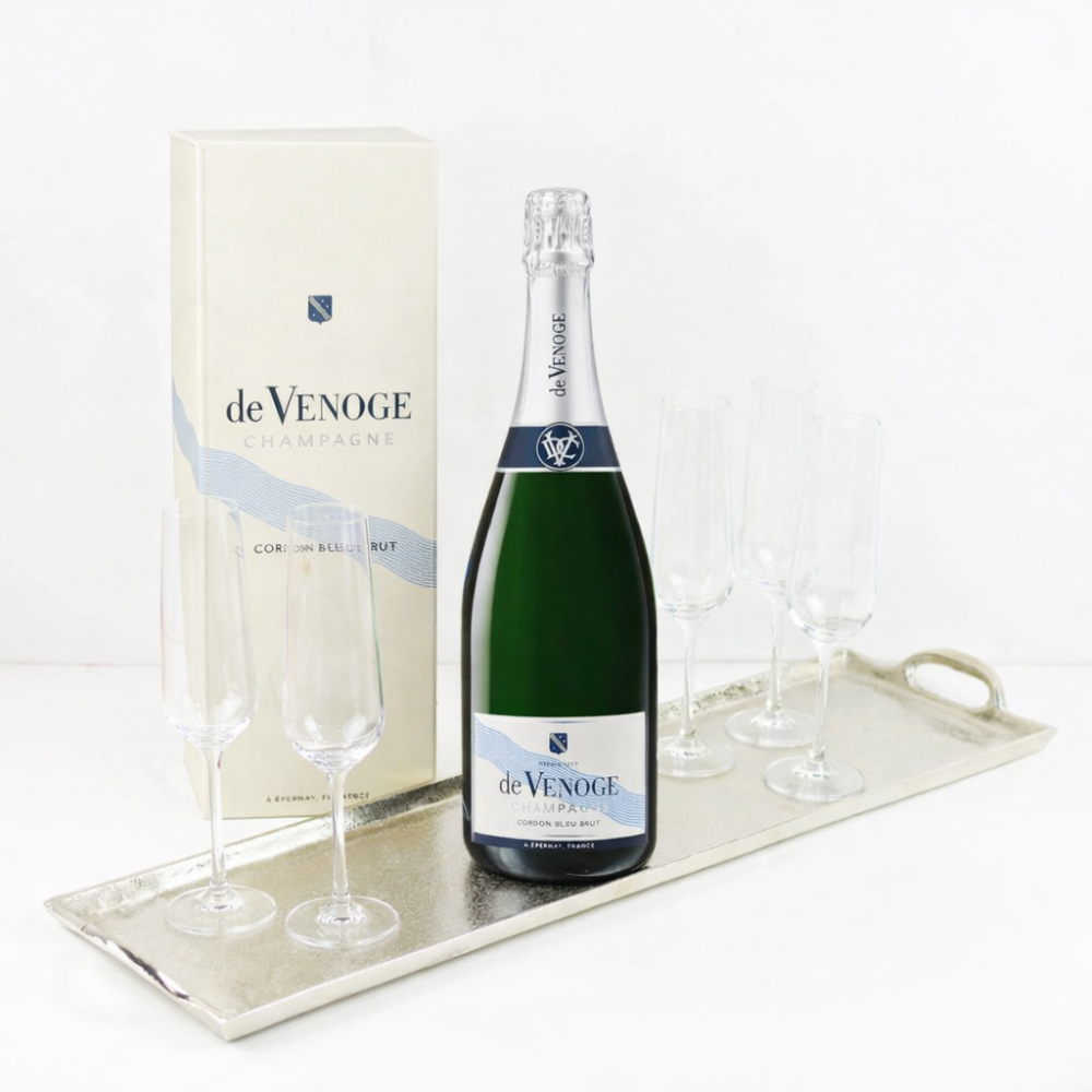 Bottle of de Venoge champagne with two glasses on a tray against a white background