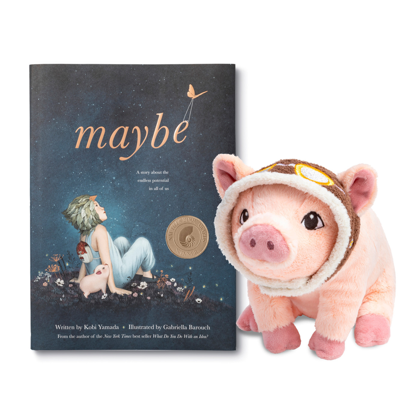 Book titled 'maybe' with a plush pig toy wearing a helmet on a white background