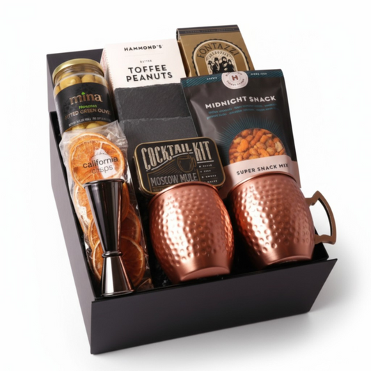 Moscow Mule Gift Box featuring two copper mugs, slate coasters, a cocktail mixer kit, and gourmet snacks. The perfect luxury client gift, birthday surprise, or gift for him. Crafted with care and featuring products made in WA.