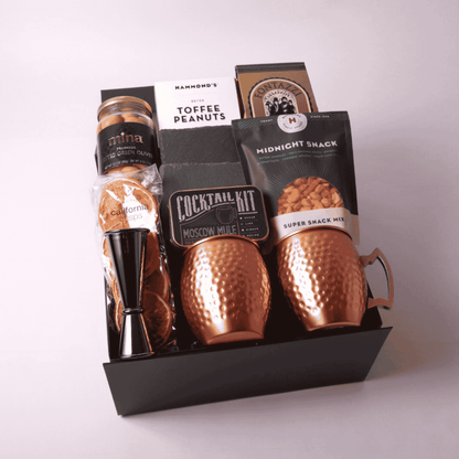 Moscow Mule Gift Box featuring two copper mugs, slate coasters, a cocktail mixer kit, and gourmet snacks. The perfect luxury client gift, birthday surprise, or gift for him. Crafted with care and featuring products made in WA.