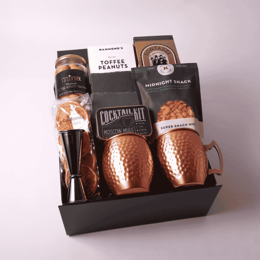 Moscow Mule Gift Box featuring two copper mugs, slate coasters, a cocktail mixer kit, and gourmet snacks. The perfect luxury client gift, birthday surprise, or gift for him. Crafted with care and featuring products made in WA.