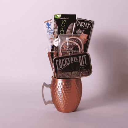 single Moscow mule mug gift basket includes a cocktail kit, two caramels, dried orange slices, crackers, pistachios and beef stick.