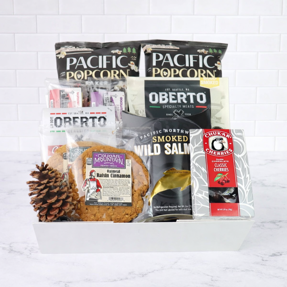 White gift box filled with pacific northwest snacks made in Washington including Pacific Popcorn, Oberto jerky, Cougar Mountain cookies, and smoked salmon
