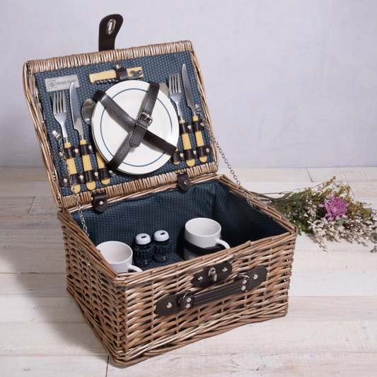 picnic basket filled with snacks from the pacific northwest including all of the plates, cups and silverware