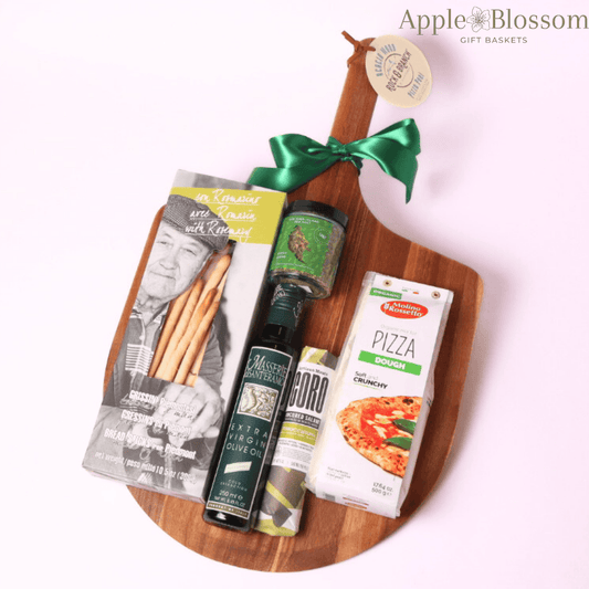 A luxury kitchen gift basket displayed on a premium pizza peel, featuring authentic Italian ingredients—an elegant and unique broker closing gift, settlement gift, or real estate closing present.