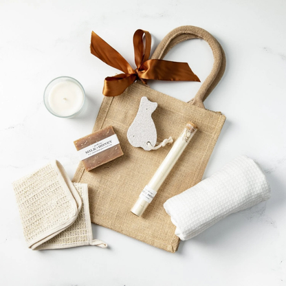 Gift set with a burlap bag, soap, towel, and other items on a white background