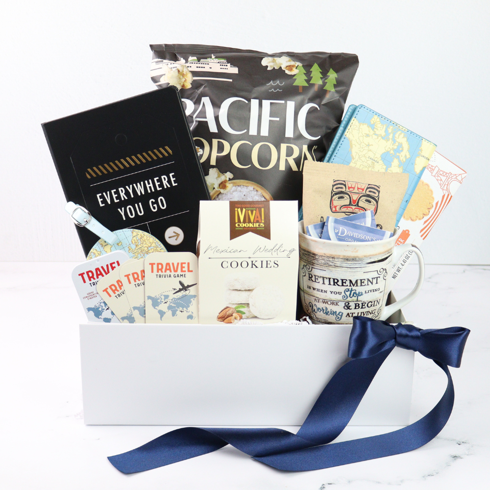 retirement Gift basket with travel-themed items including a retired mug, passport cover, luggage tag, book, cookies, and books on a white background