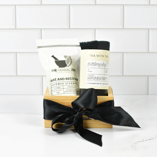 Rise & Recharge spa gift set with shower steamers, green tea sachets, and black washcloth in elegant gift packaging