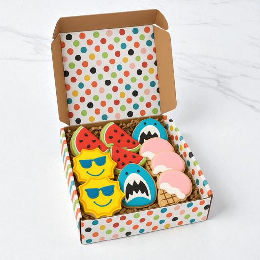 Colorful cookies shaped like a sun, shark, and ice cream in a polka dot box on a white background