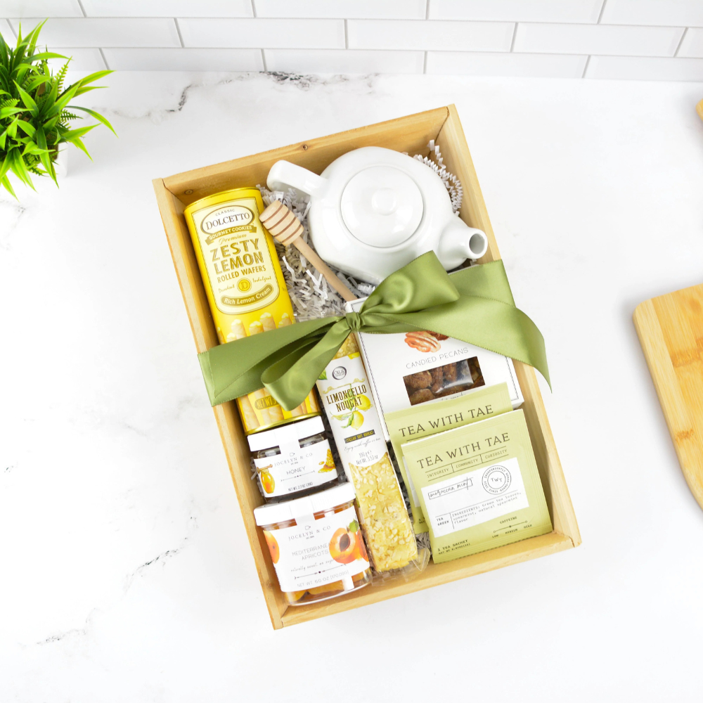 Tea Break gift basket with white ceramic teapot, premium tea selection, honey, lemon cookies, and artisan treats in a keepsake box