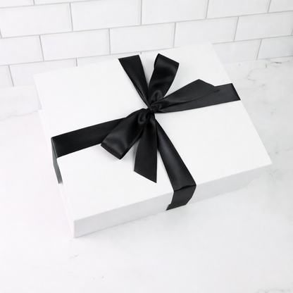 White gift box with a black ribbon on a white background